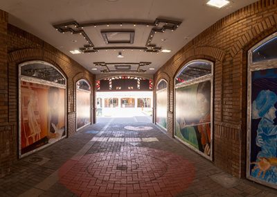 Brick alleyway with colorful murals on walls