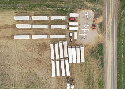 Aerial view of trucks parked on dirt lot.