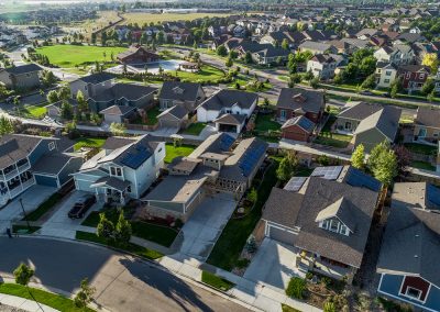 Aerial view of suburban neighborhood with green spaces.