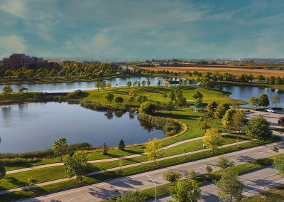 Scenic park with lake and walking paths.